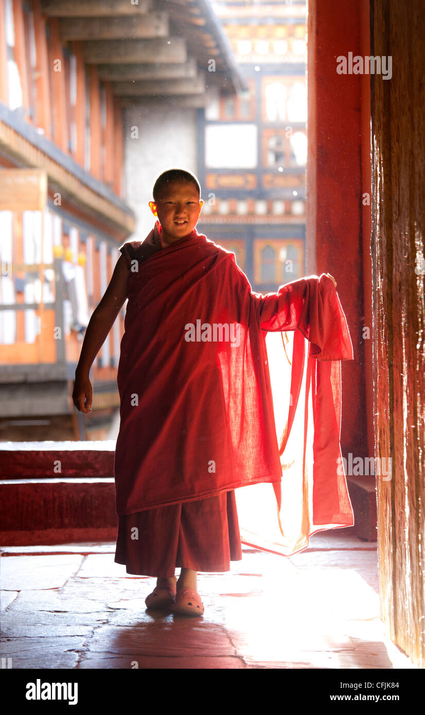 Jeune moine bouddhiste en robes rouges soirée rétro-éclairé par lumière du soleil à l'Jakar Dzong, Jakar, Bumthang, Bhoutan, Asie Banque D'Images