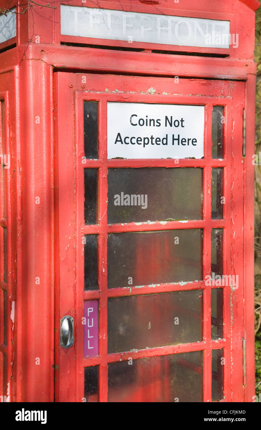 Boîte de téléphone rouge traditionnel en zone rurale avec panneau disant pièces qui ne sont pas accepté Banque D'Images