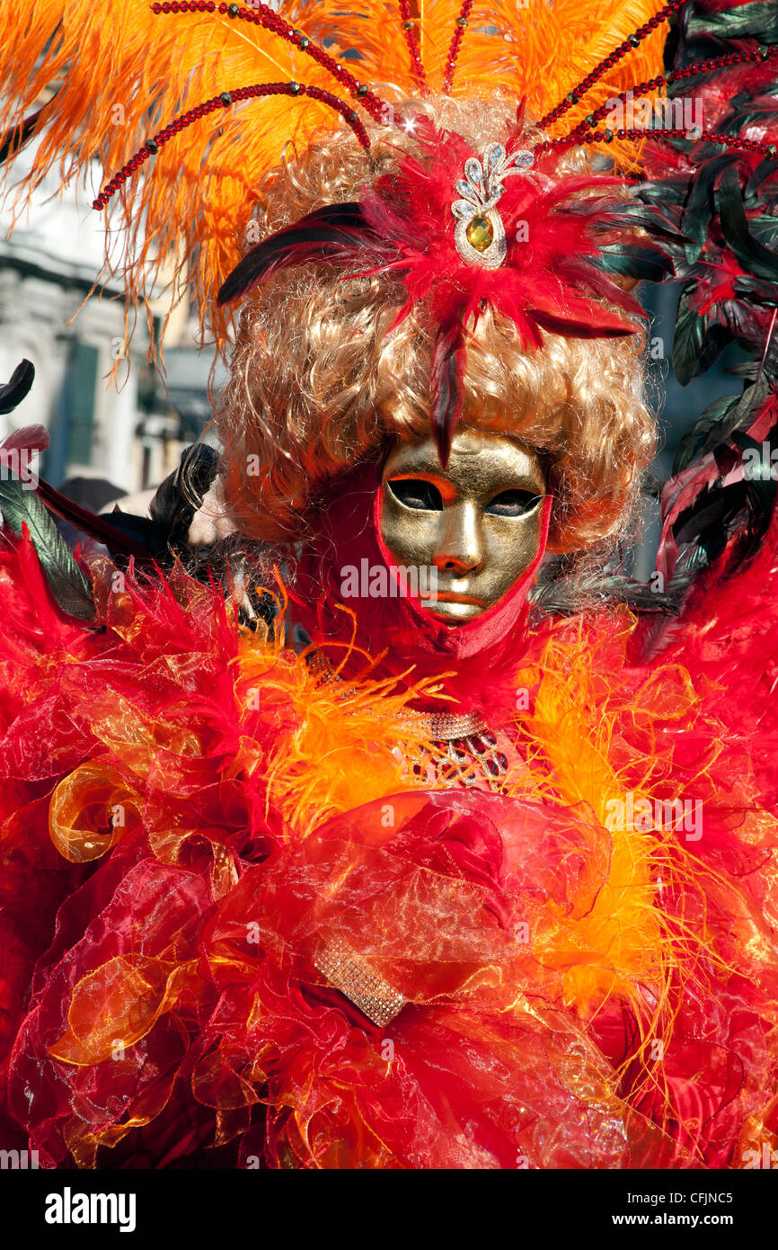 Personne habillé en orange et rouge costume de carnaval pour le Carnaval de Venise 2012, Place Saint Marc Venise Italie Banque D'Images