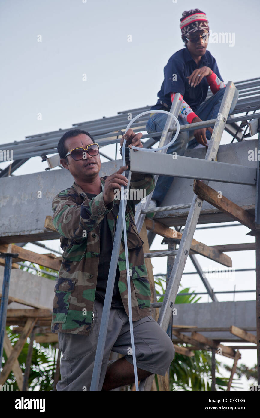 Un Thaï Builder en utilisant un tube de niveau d'eau, Phuket, Thailand Banque D'Images