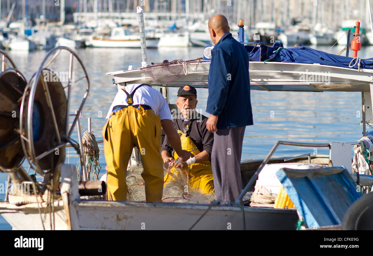 Les pêcheurs démêler des poissons d'un filet de pêche. Vieux-port. Marché aux poissons. Marseille. Banque D'Images