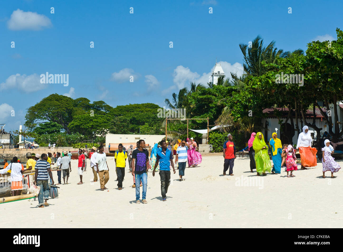 Les gens qui marchent le long de la plage de Stone Town Zanzibar Tanzanie Banque D'Images