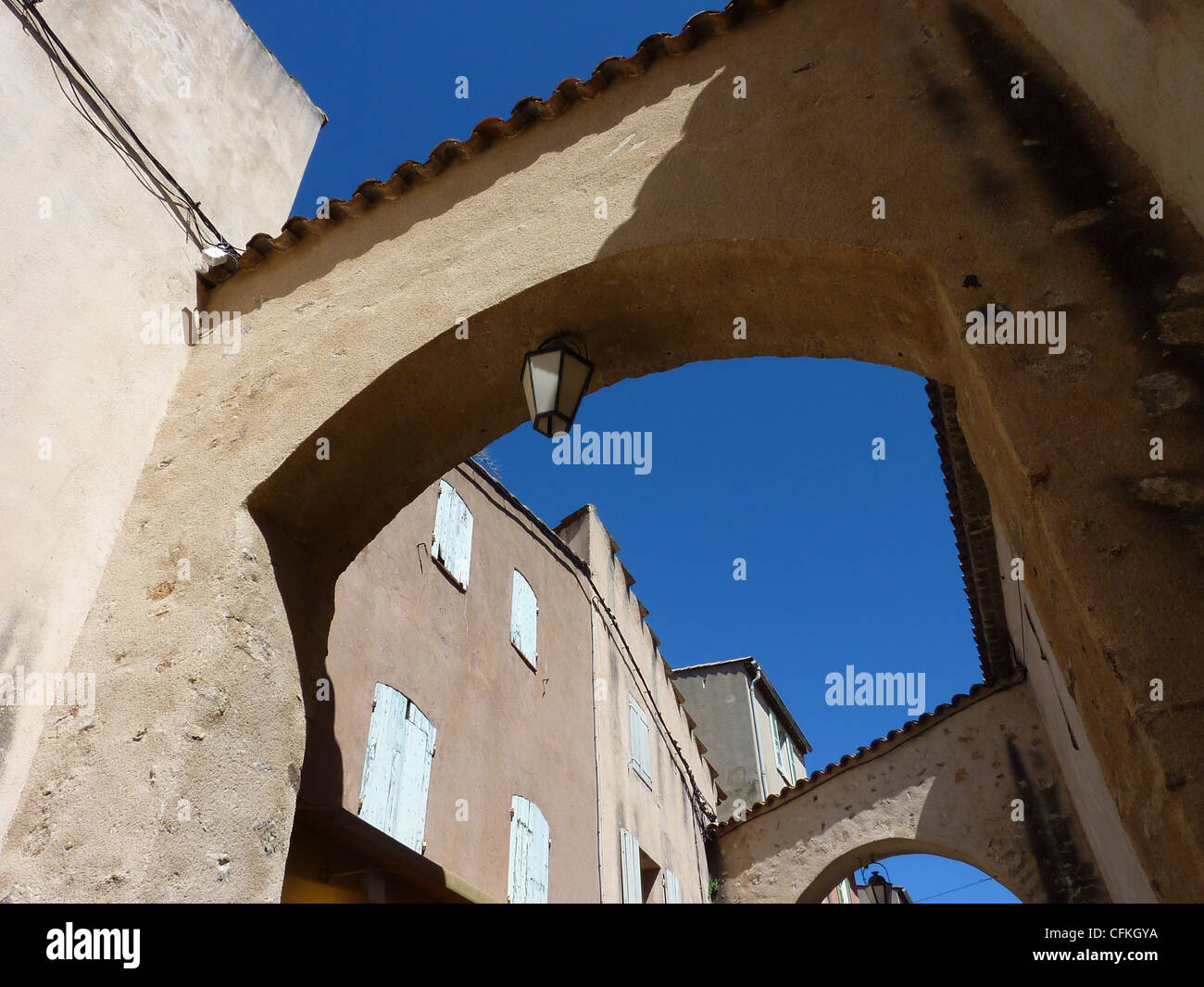 Arch avec lampe et bâtiments avec des volets fermés, à Saint-Tropez, France, par beau temps Banque D'Images