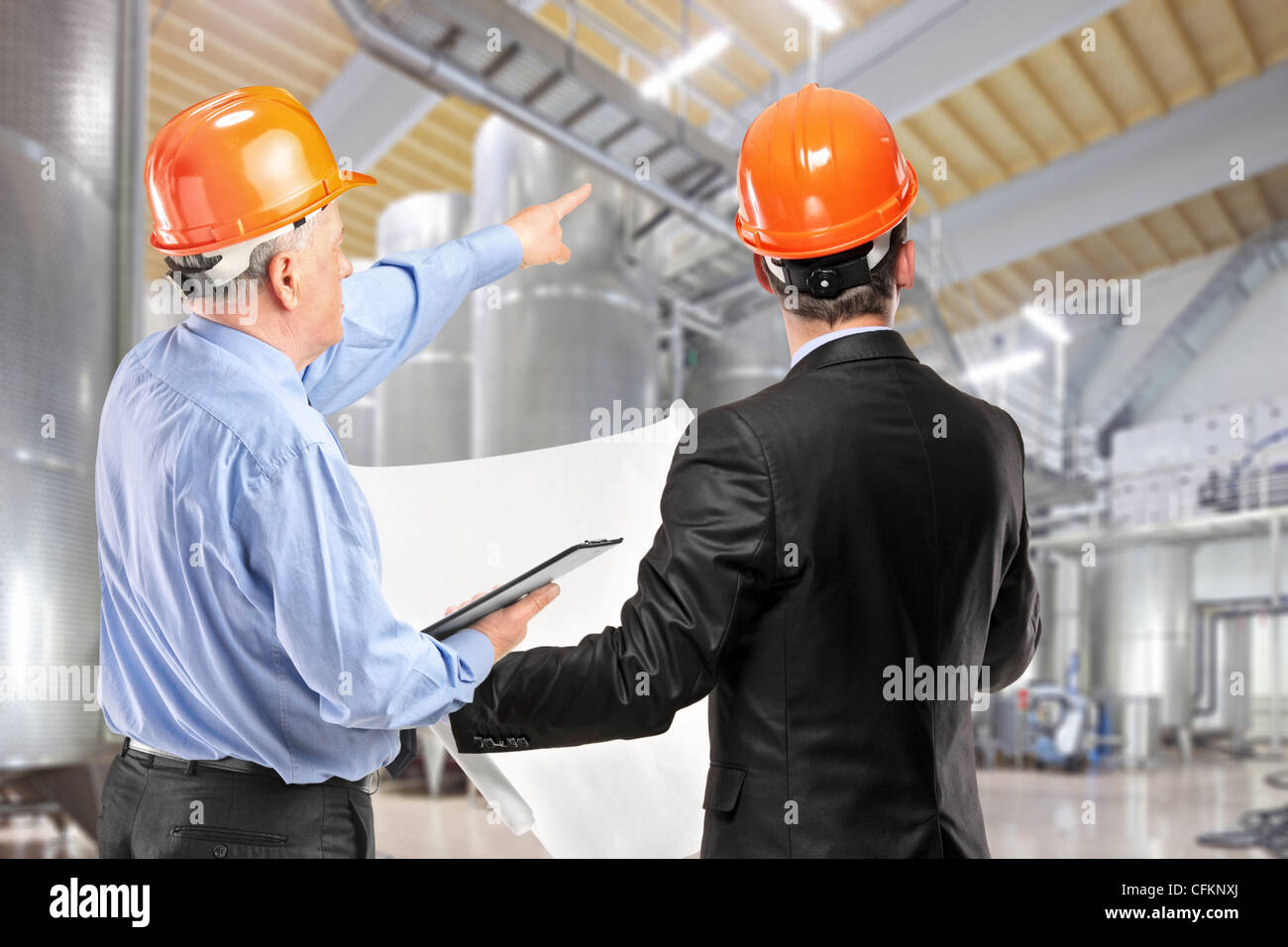 Une équipe de travailleurs de la construction avec un casque orange sur le lieu de travail dans une usine Banque D'Images