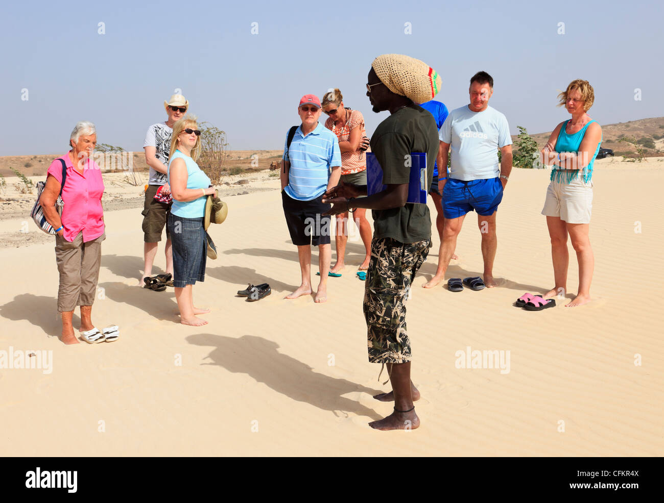 Deserto de Viana : Boa Vista Cap Vert Black tour guide parlant à un groupe de touristes visitant désert caucasienne Banque D'Images