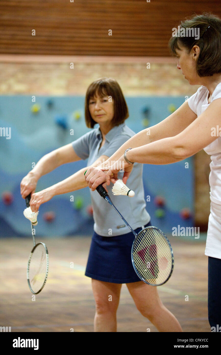 Women sport UK; Un entraîneur de badminton enseignant à une femme joueur comment servir, Newmarket, Suffolk, Royaume-Uni Banque D'Images