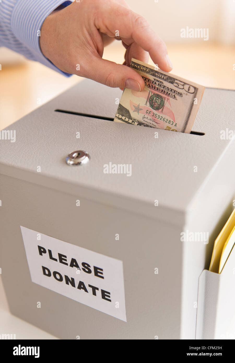 Jersey City, New Jersey, la main de l'homme mettre des dollars dans boîte de donation Banque D'Images