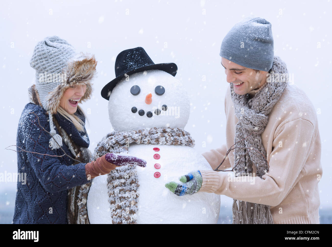USA, New Jersey, Jersey City, Couple making snowman Banque D'Images
