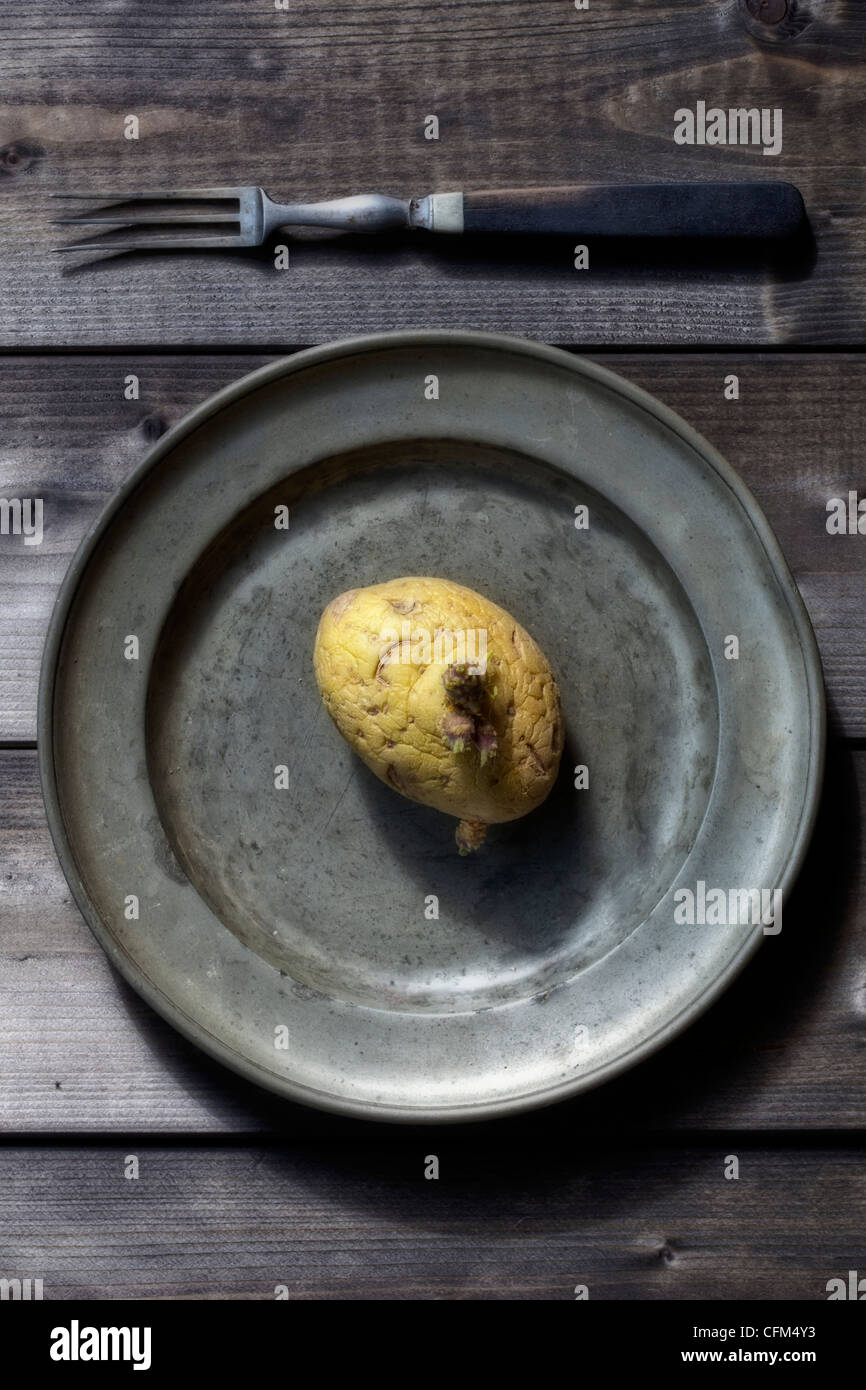 Vieux, ratatinées aux germes de pommes de terre sur la plaque d'anciens avec une fourchette Banque D'Images