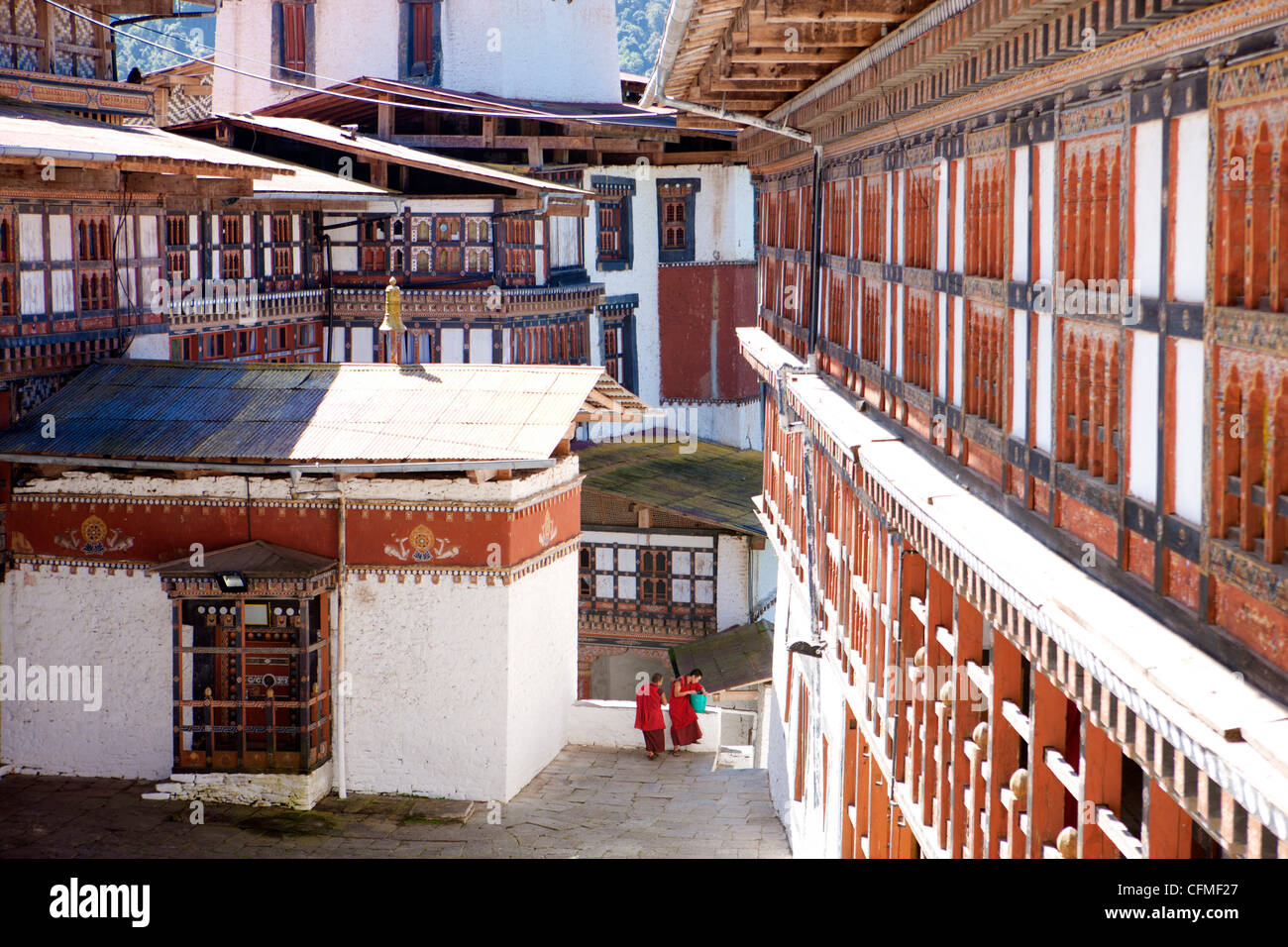 Deux moines bouddhistes chat contre l'impressionnant de Trongsa Dzong, Trongsa, Bhoutan, Asie Banque D'Images