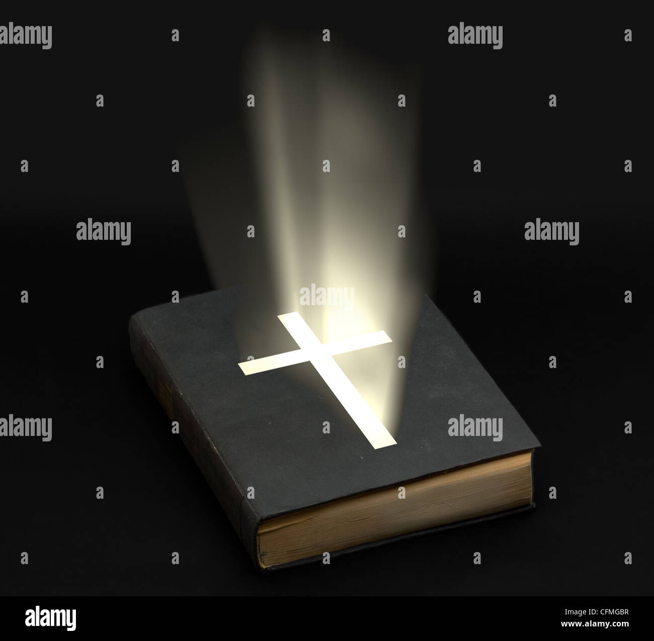 La Sainte Bible avec croix brillant sur fond noir Banque D'Images