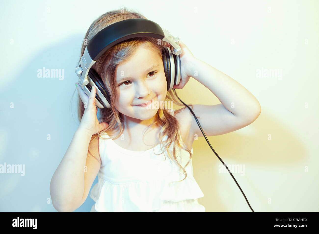 Studio Portrait of Girl (4-5) listening to music on headphones Banque D'Images
