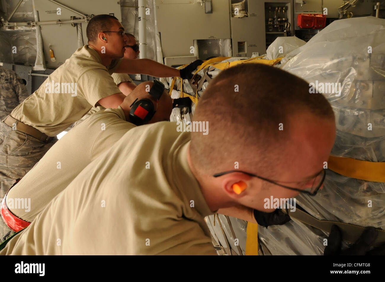 Des aviateurs de la 386e Escadre expéditionnaire aérienne des États-Unis chargent des munitions sur un Globemaster C-17 à un endroit non divulgué en Asie du Sud-Ouest, le 15 mars 2012. Les aviateurs de la 386e AEW jouent un rôle important dans la manipulation d’aéronefs qui fournissent des capacités de combat et de soutien à des opérations conjointes dans l’ensemble de la zone de responsabilité du Commandement central des États-Unis. Banque D'Images
