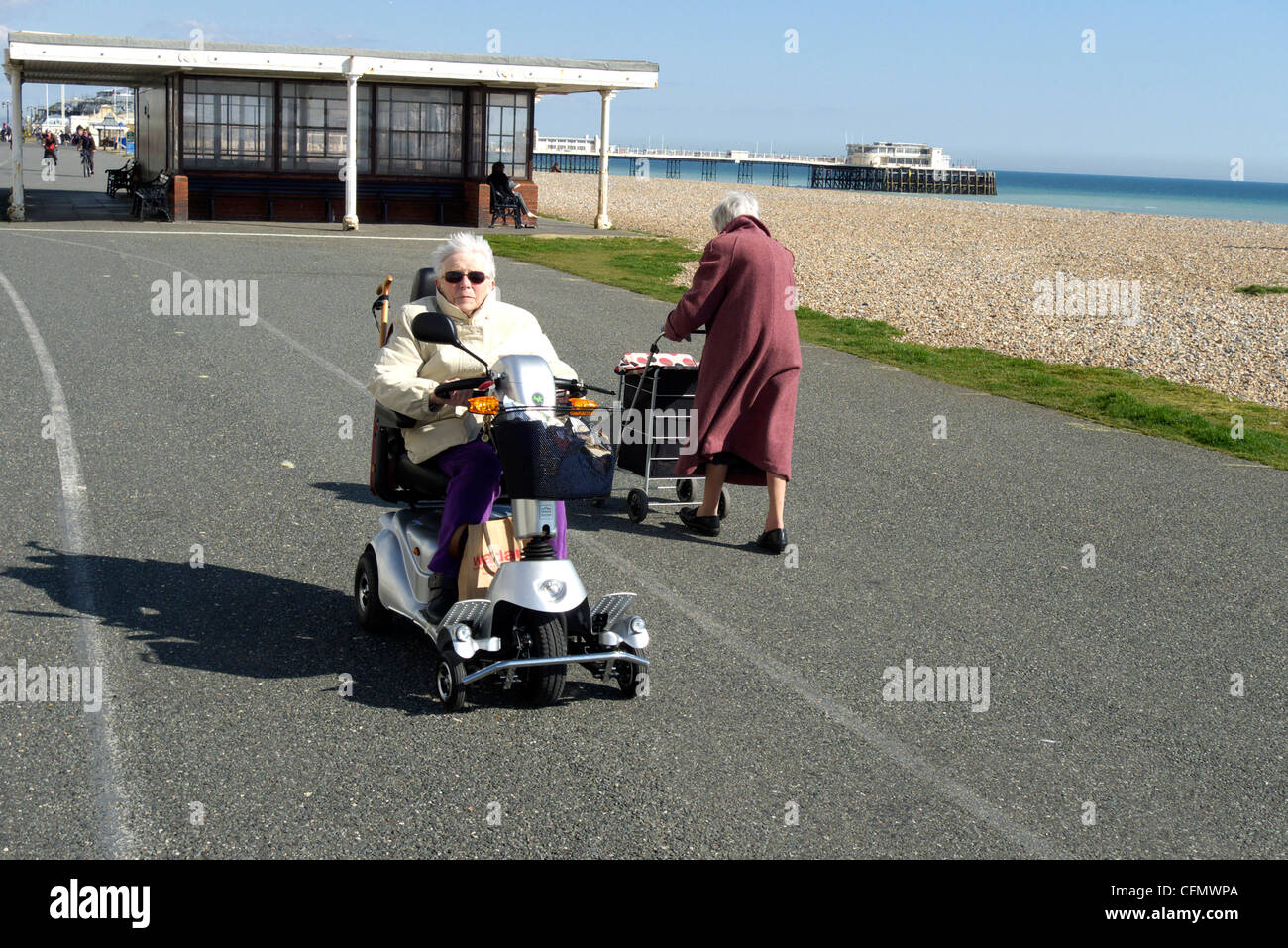 Worthing West Sussex Royaume-Uni une vieille dame sur une mobilité shoprider triporteur sur la promenade Banque D'Images