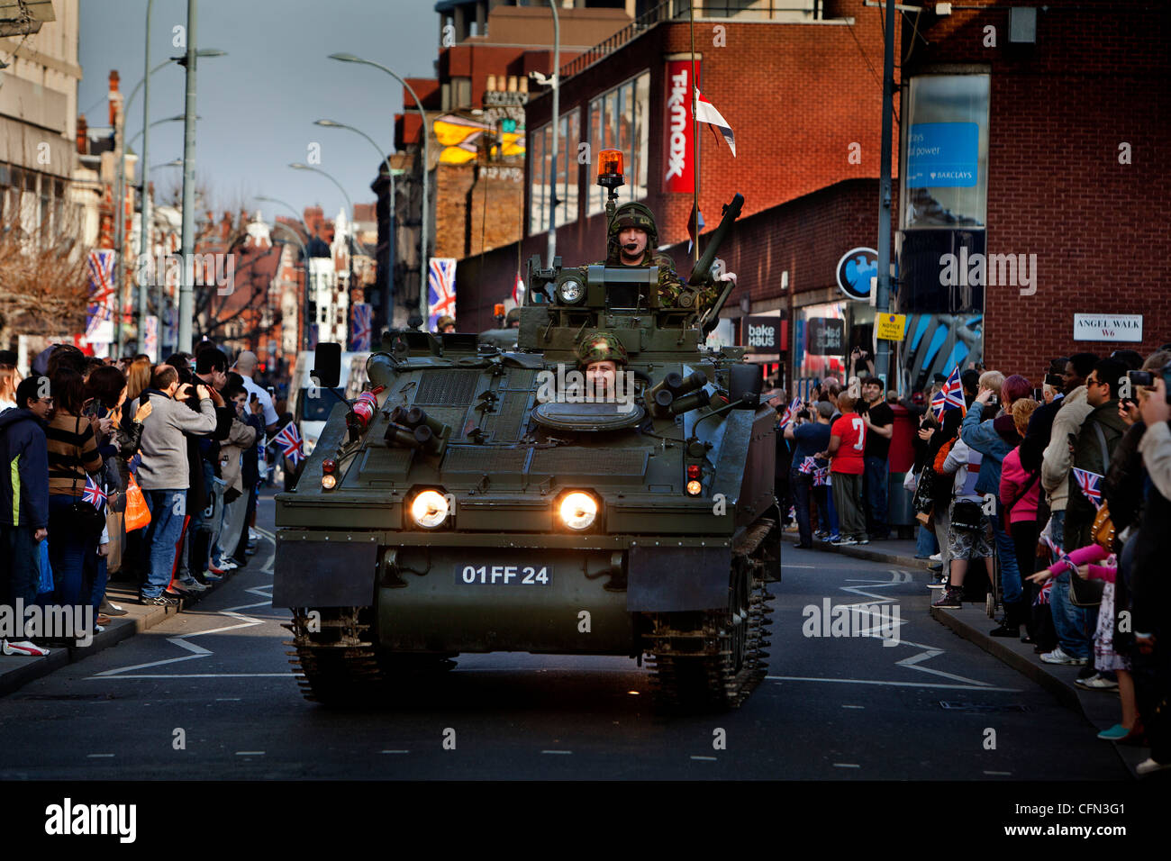 Dans les véhicules blindés des troupes passer devant des boutiques de High street pendant un défilé royal Yeomanry, spectateurs regarder à partir de la chaussée Banque D'Images