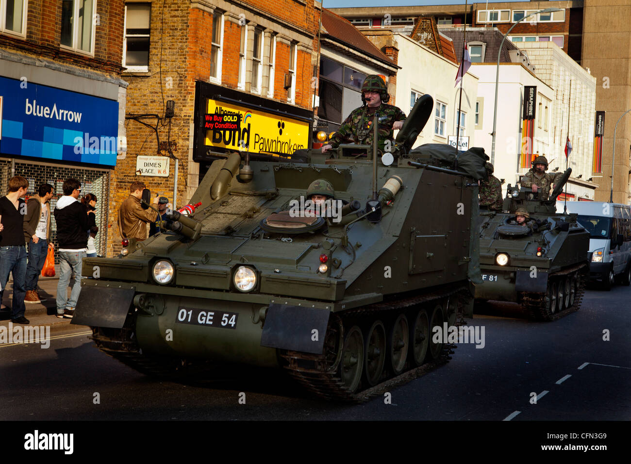 Dans les véhicules blindés des troupes passer devant des boutiques de High Street pendant un défilé royal Yeomanry Banque D'Images