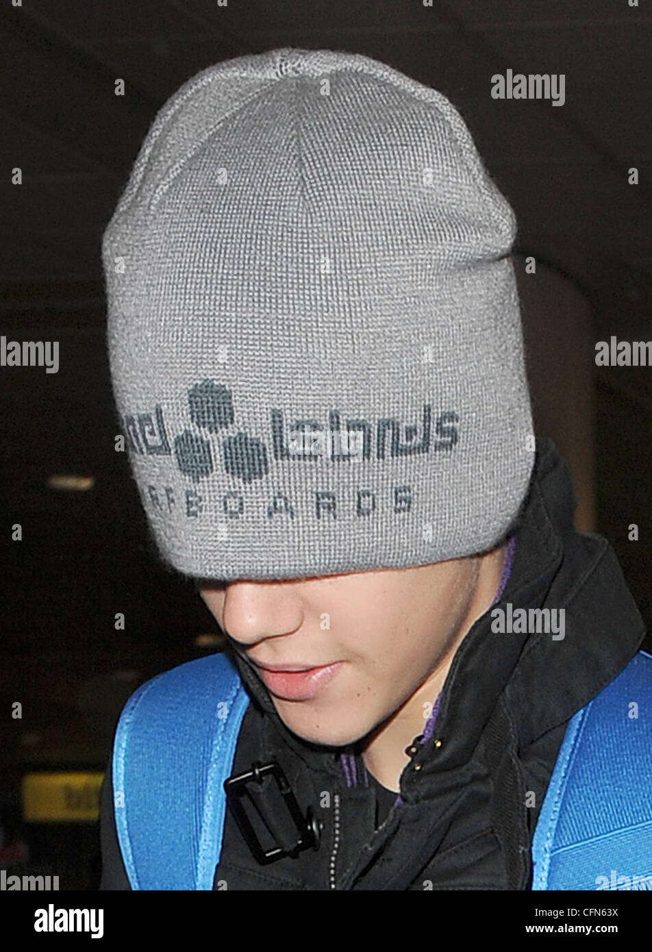 Justin Bieber à gauche des dizaines d'adolescentes déçu qu'il est arrivé  dans l'aéroport d'Heathrow sans message d'eux. Bieber a sorti son chapeau  bonnet gris sur la tête - obstruction à sa vision -