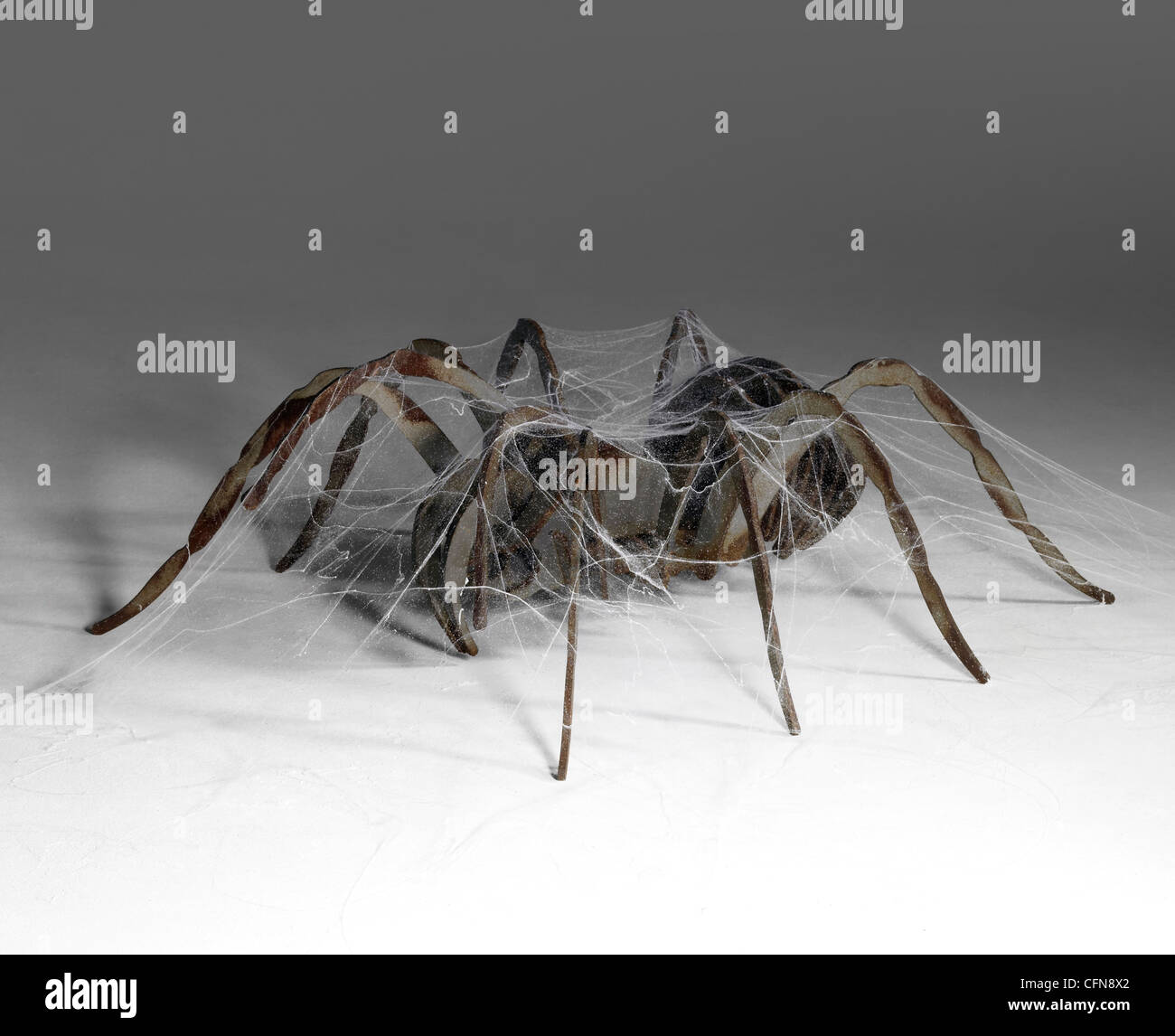 L'araignée métallique corrodé recouvert de toiles d'araignée artificielles Banque D'Images