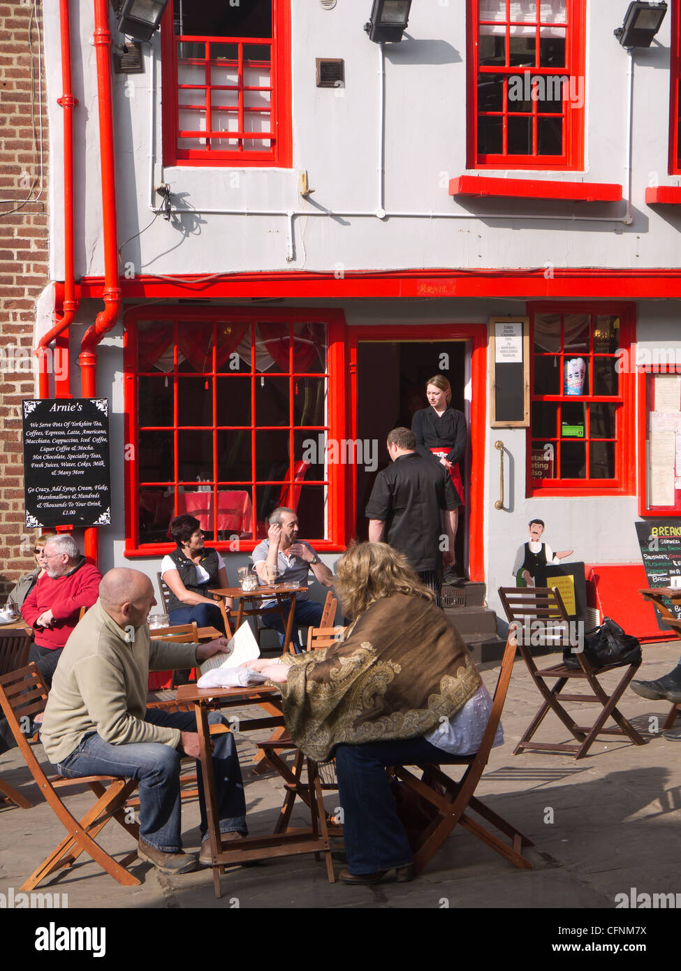 Les touristes appréciant un repos et rafraîchissement à l'extérieur des tables de Arnie's Café Bistro dans Market Place Whitby North Yorkshire Banque D'Images