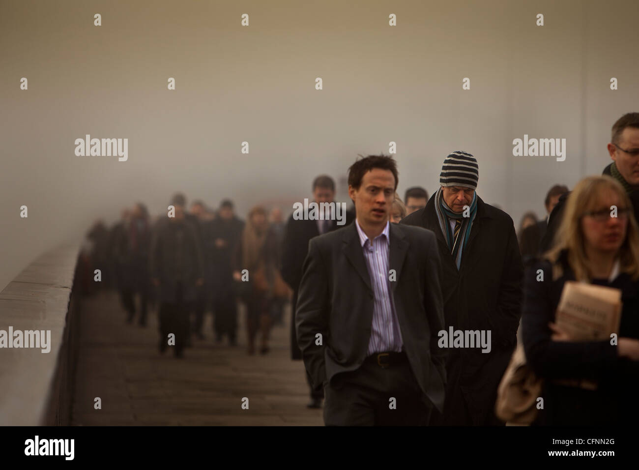 Les navetteurs traversant le pont de Londres sur un matin de smog Banque D'Images