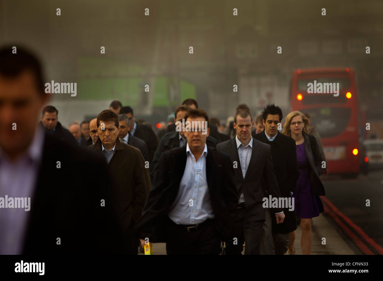 Les navetteurs et occupé le trafic traversant le pont de Londres sur un matin de smog Banque D'Images