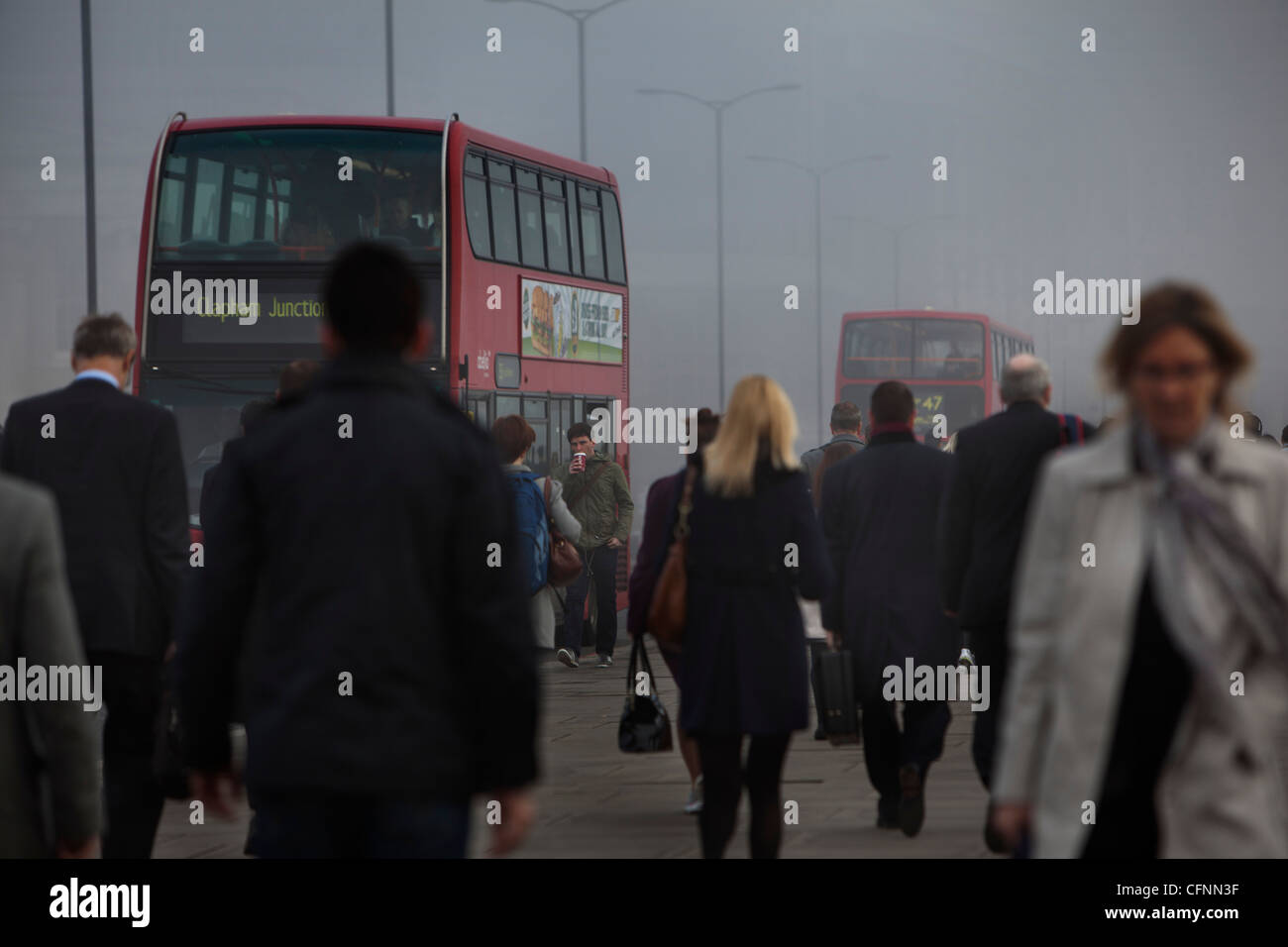Les navetteurs et occupé le trafic traversant le pont de Londres sur un matin de smog Banque D'Images