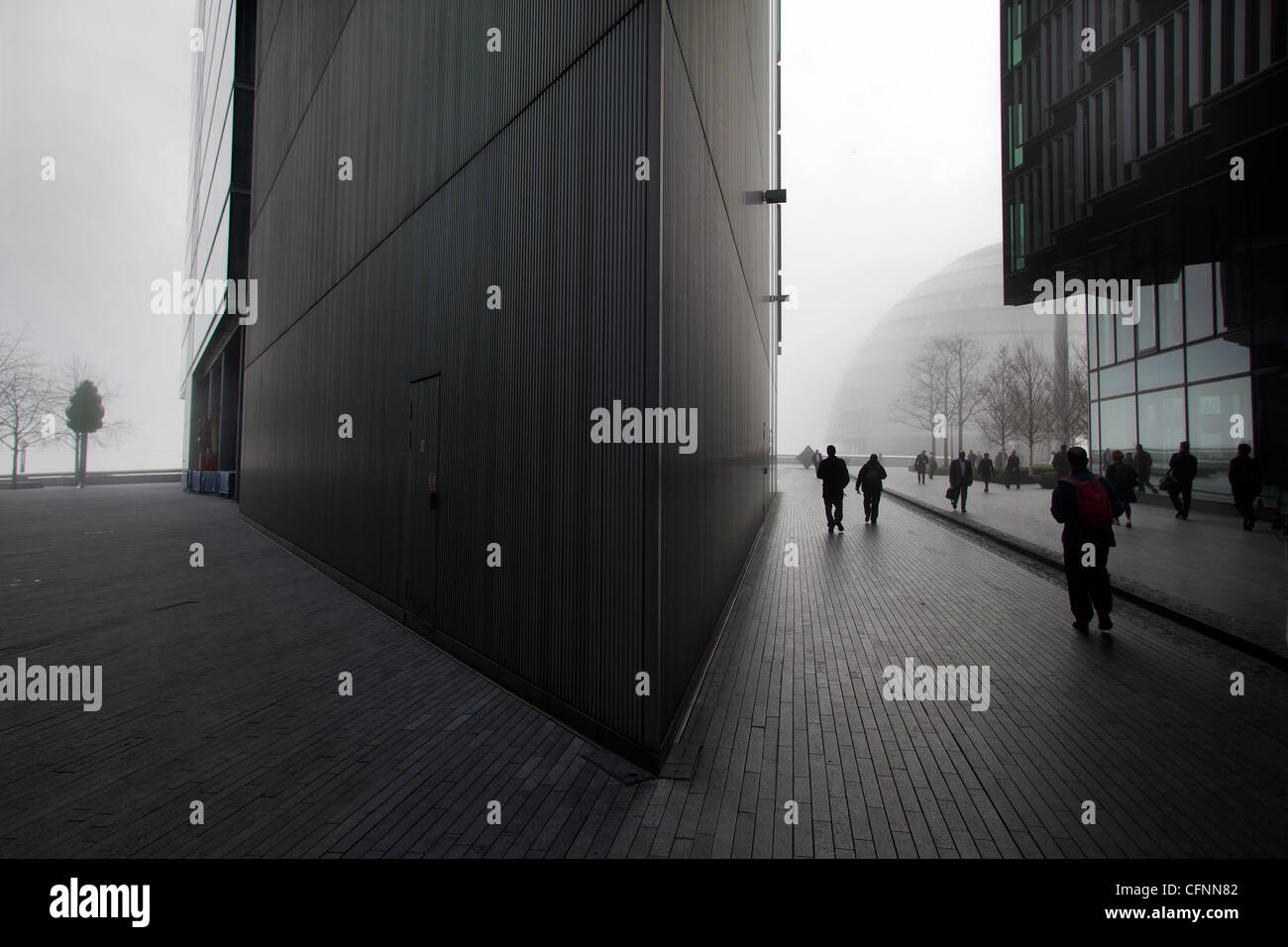 Les banlieusards de marcher dans les bâtiments de la zone de développement plus Londres dans le brouillard du matin Banque D'Images
