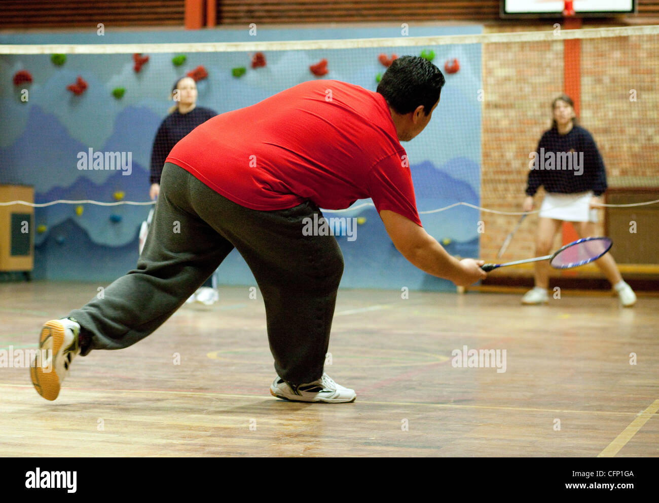 Body Diversity UK dans le sport; un homme obèse jouant un jeu de Badminton dans un club local, Royaume-Uni Banque D'Images