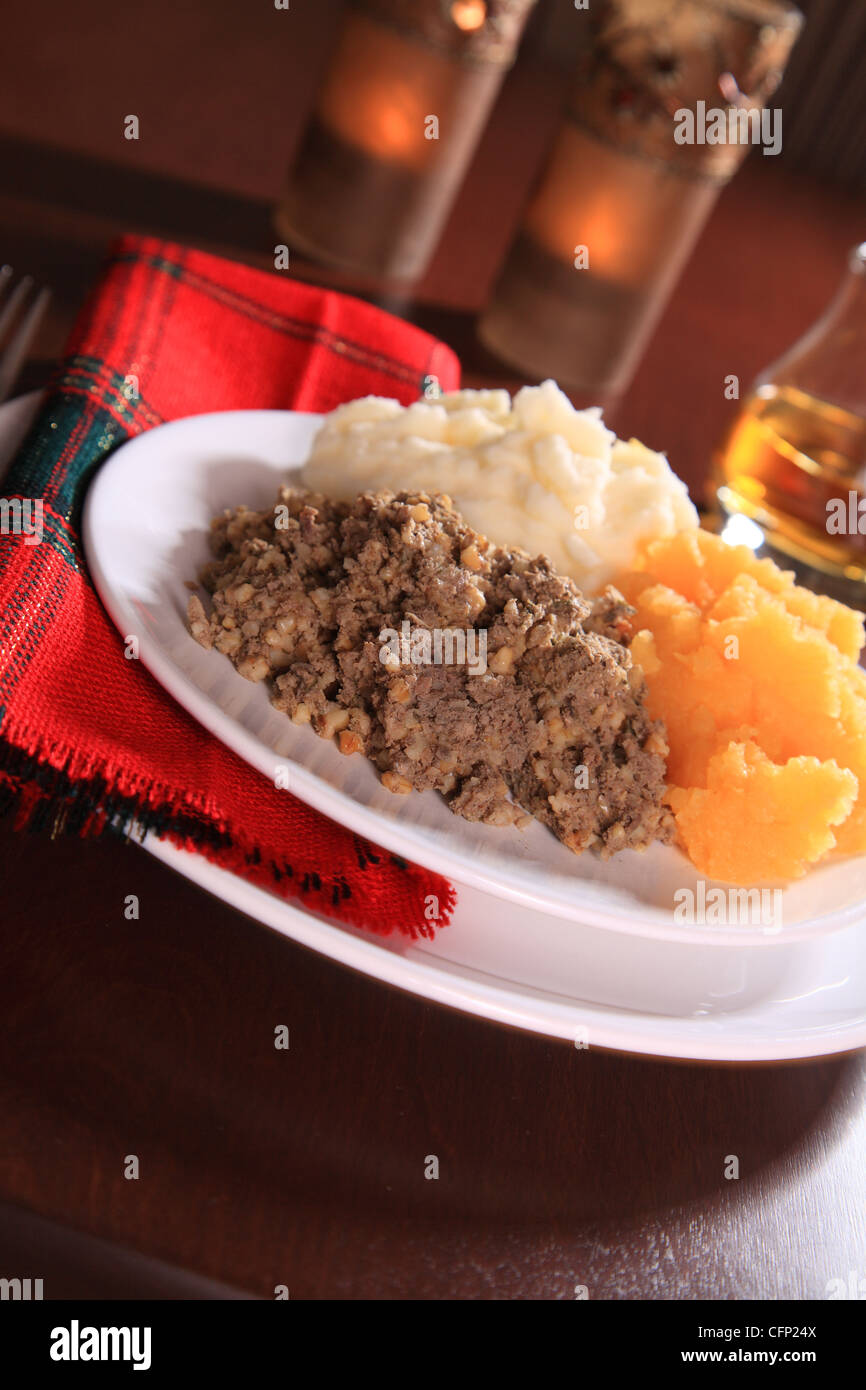 Scottish Haggis sert pour UN dîner de nuit Burns contre UN Royal Stuart Tartan célébrant l'anniversaire Robert Burns l'écossais Poète le 25 janvier Banque D'Images