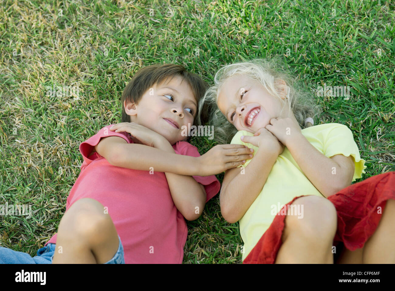 Jeunes amis lying together on grass Banque D'Images