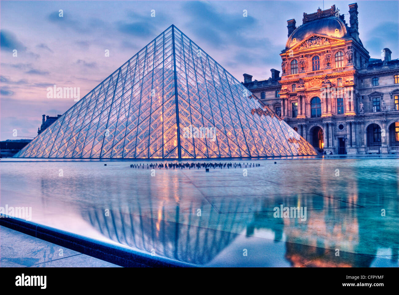 Le Louvre au crépuscule avec sa pyramide de verre entrée. Banque D'Images