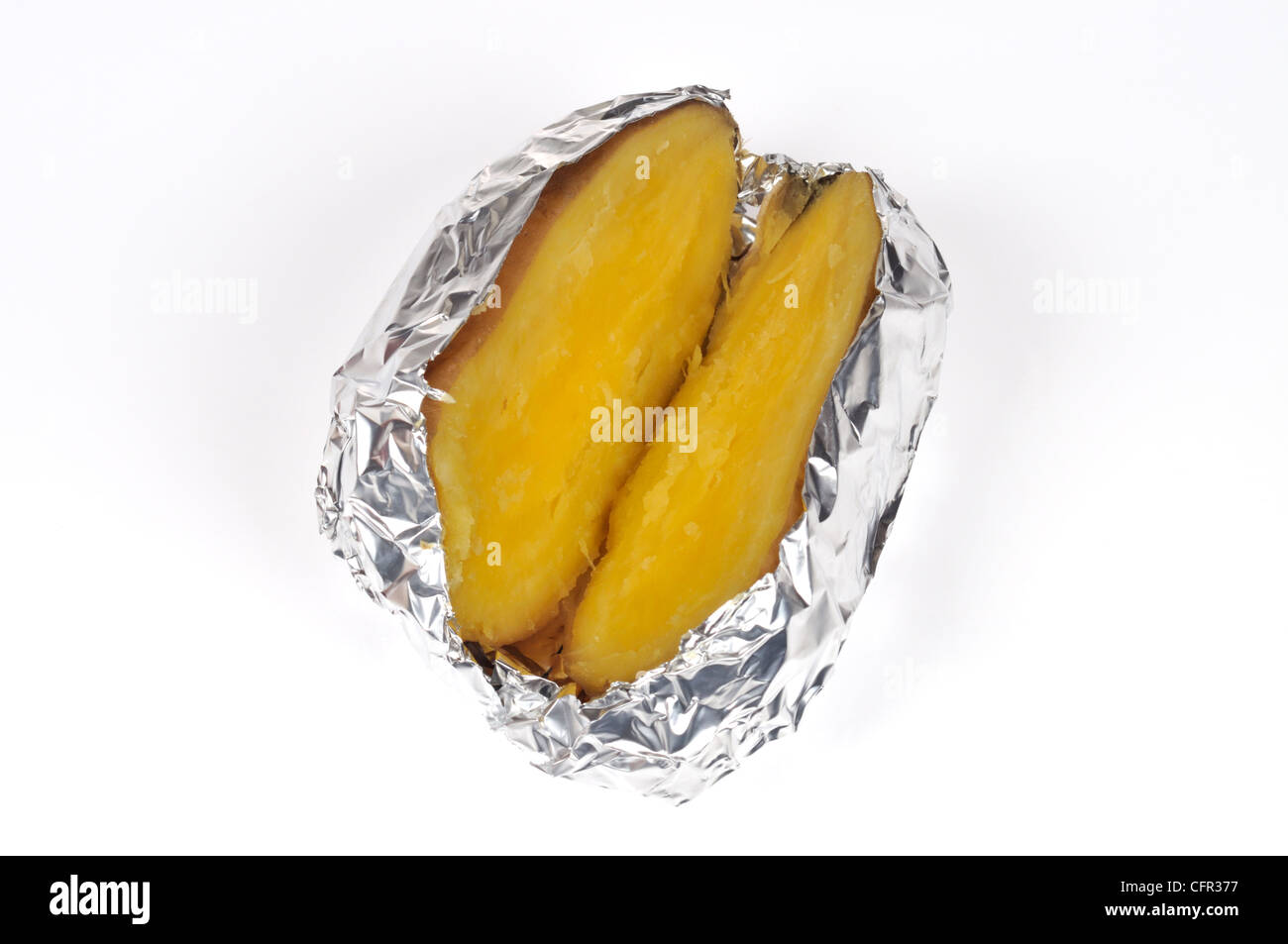 Cuit Cuit des pommes de terre Yukon Gold veste réduit de moitié enveloppé dans du papier d'aluminium sur fond blanc, cut out Banque D'Images