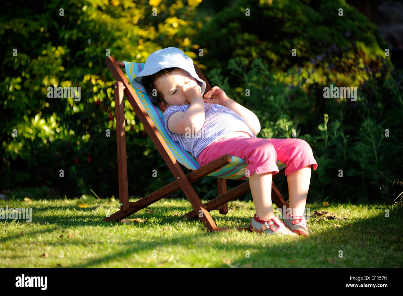 Une jeune fille dormir dans une chaise longue au soleil Banque D'Images