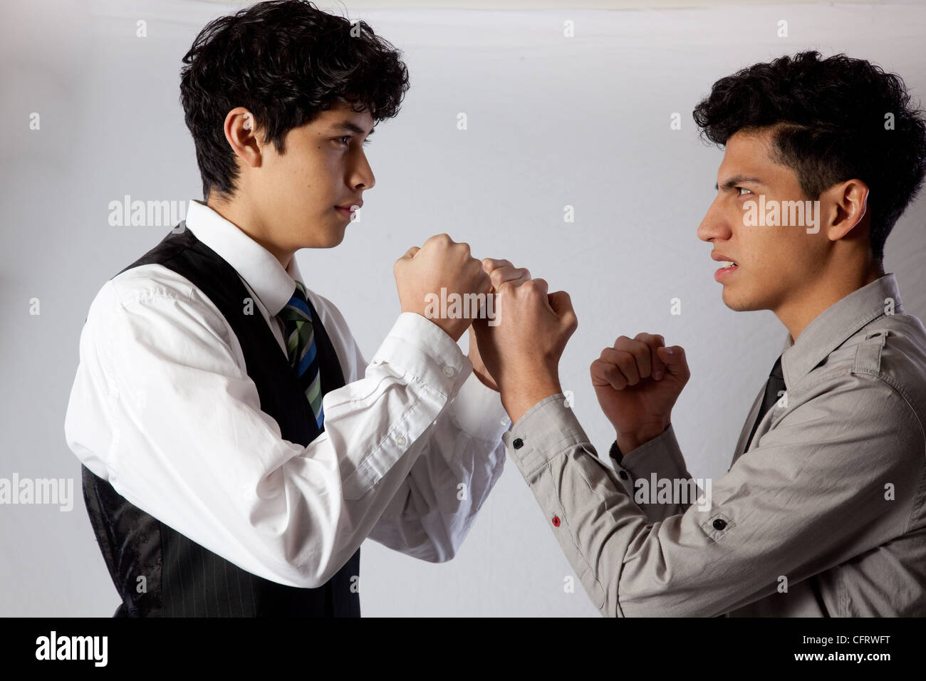 Beau, jeune, hispanique, frère d'affaires dans l'habillement, de poings en prêt à se battre les uns contre les autres Banque D'Images