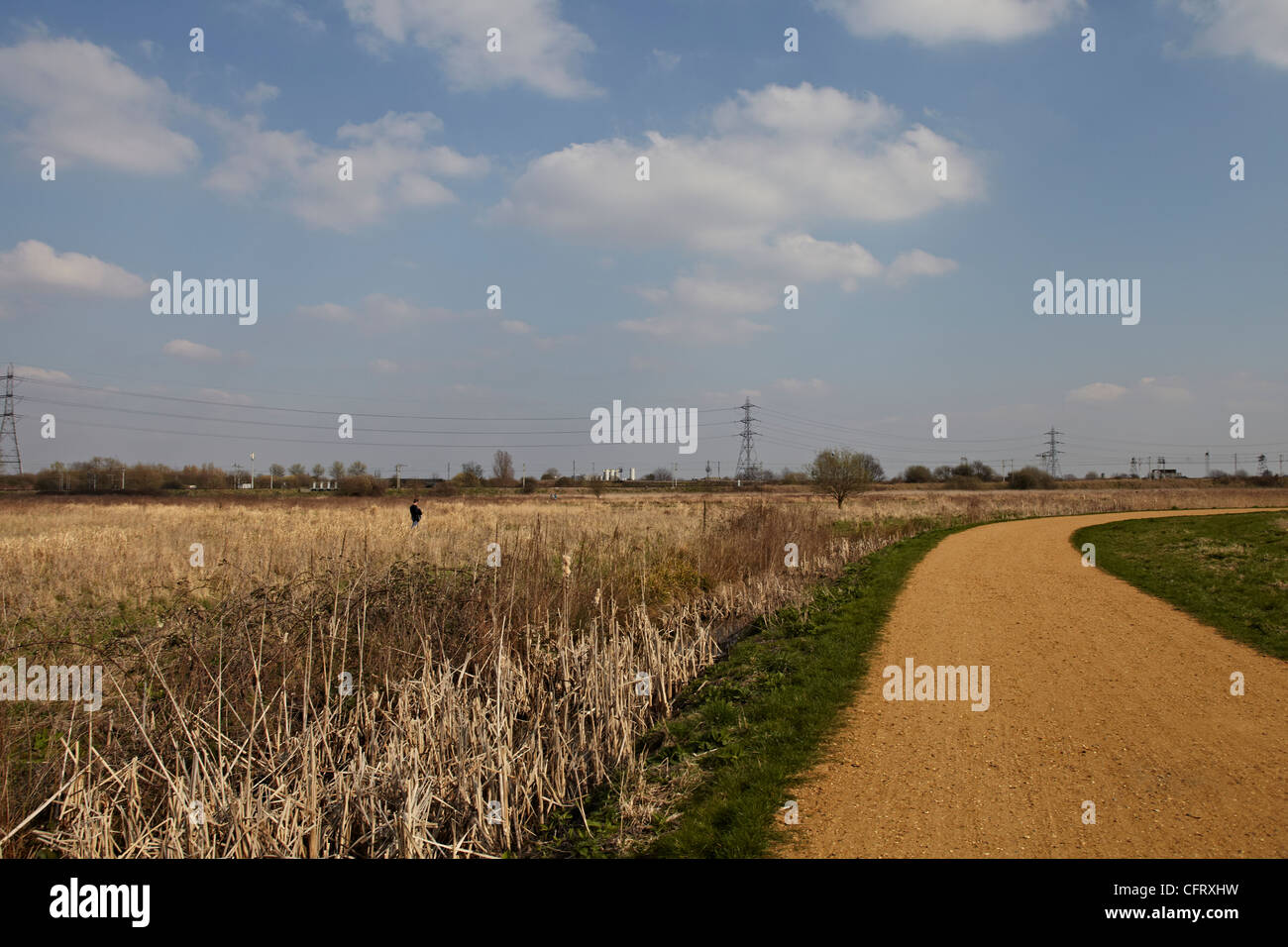 Deux personnes dans la distance bénéficiant d'une promenade dans la campagne ouverte sur une journée ensoleillée à Walthamstow marais Banque D'Images
