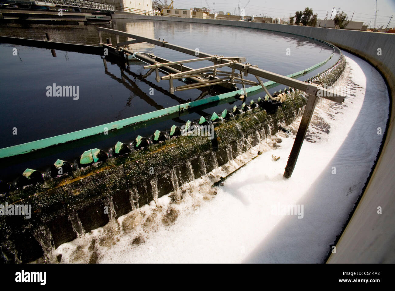 Un balayage rotatif "secondary goutte filtre décanteur d'écumage' écume à  la surface des eaux usées dans un réservoir de décantation à une usine de  traitement de l'eau à Fountain Valley, CA Photo