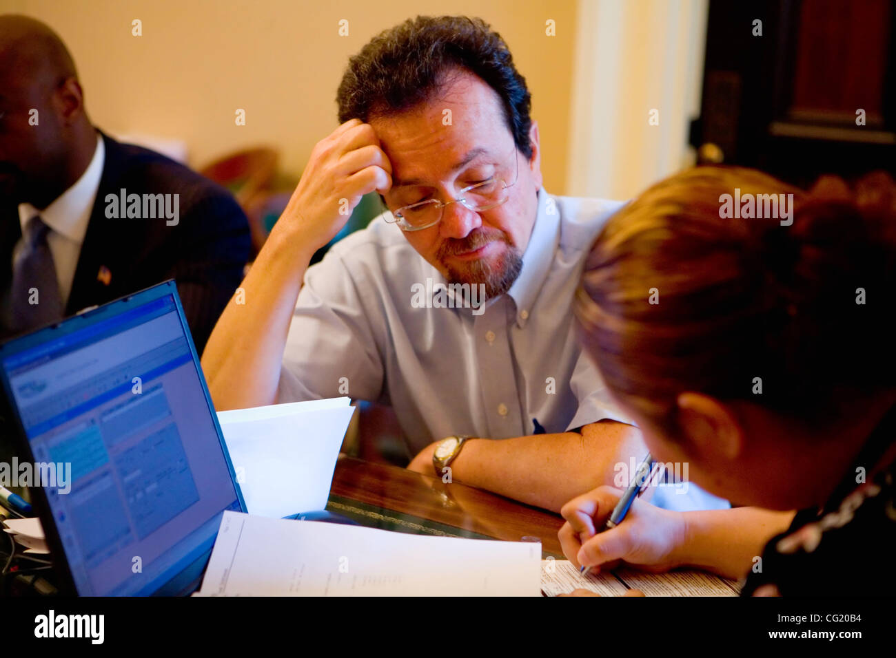 Travailleur législatif, Ray Sotero, Directrice des communications pour le sénateur Jenny Oropeza, fonctionne avec un employé d'or Credit Union, Ko Lee, alors qu'il signe pour un prêt sans intérêt, le mardi 10 juillet 2007. Les travailleurs ne seront pas de recevoir un chèque de paie alors que l'Etat continue de fonctionner sans budget. Sacrame Banque D'Images