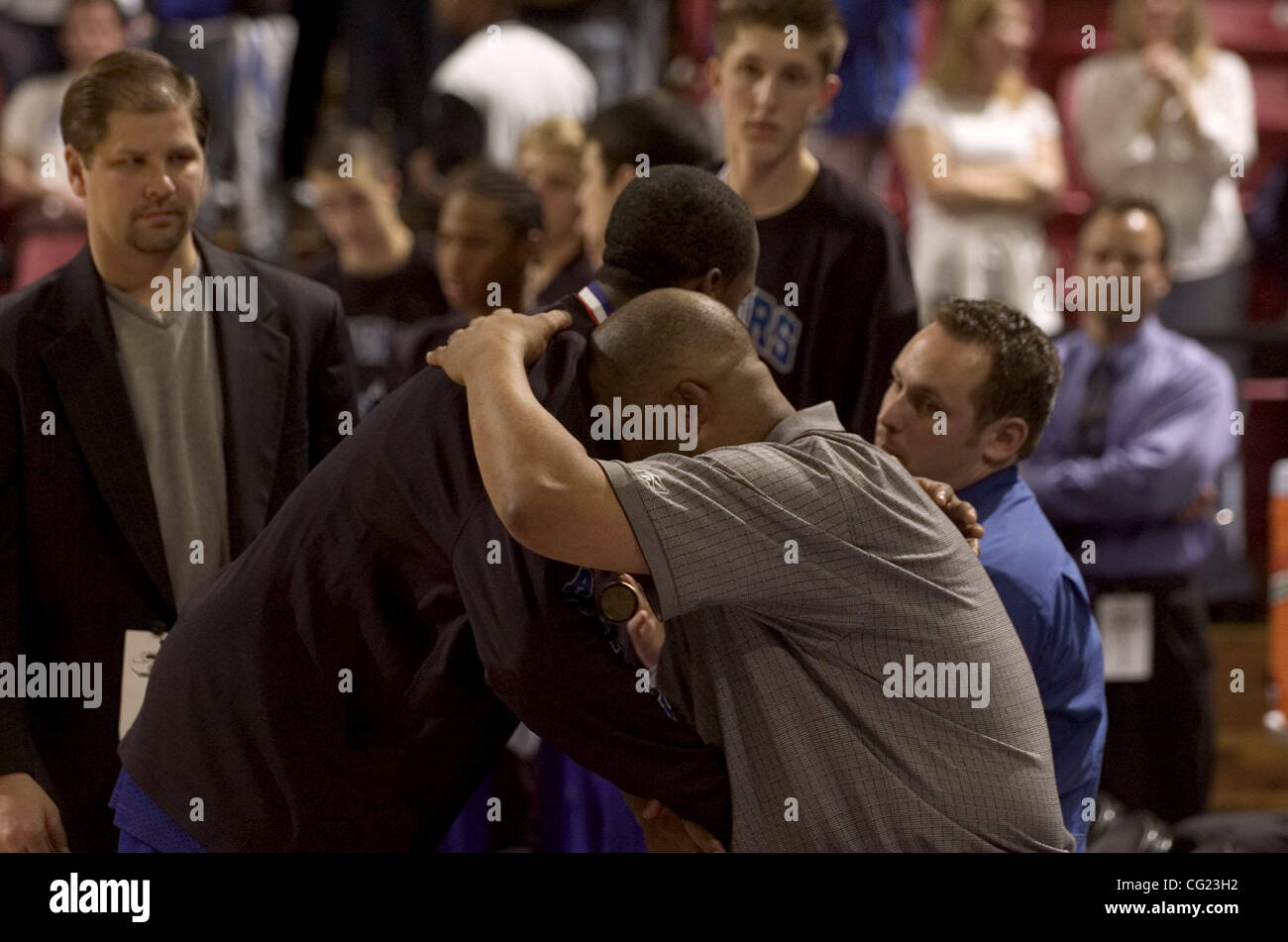 Capitol Christian couguars entraîneur Bill Nelson embrasse l'un de ses joueurs à la fin du 4e trimestre avant de perdre au Modesto Christian croisés en Vendredi soir Les garçons de la Section V Section CAF jeu final entre Capitol Christian et Modesto Christian au Arco Arena de Sacramento, en Californie. Modesto Ch Banque D'Images