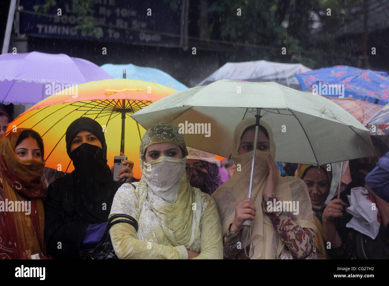 Les professeurs contractuels du cachemire tenir parapluie dans les précipitations au cours de 15 jours de grève de la faim .à Srinagar, la capitale d'été du Cachemire indien, le 12/8/2011 Photo/Altaf Zargar/Zuma Press Banque D'Images