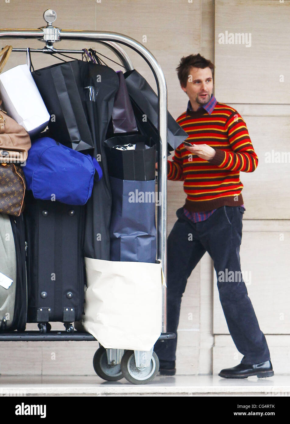 Matt Bellamy pousse le chariot à bagages à l'extérieur de son hôtel à Londres, Londres, Angleterre - 29.01.11 Banque D'Images