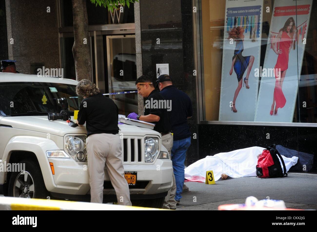 24 août 2012 - Manhattan, New York, États-Unis - La Police d'oeil sur le corps de l'ex-patron aurait été abattu par le feu travailleur mode Jeffrey Johnson se trouve sur la 33e Rue trottoir en face de l'Empire State Building. Johnson, 53 ans, a été abattu par la police sur la Cinquième Avenue. (Crédit Image : © Bryan Smith/ZUMAPRESS.com) Banque D'Images