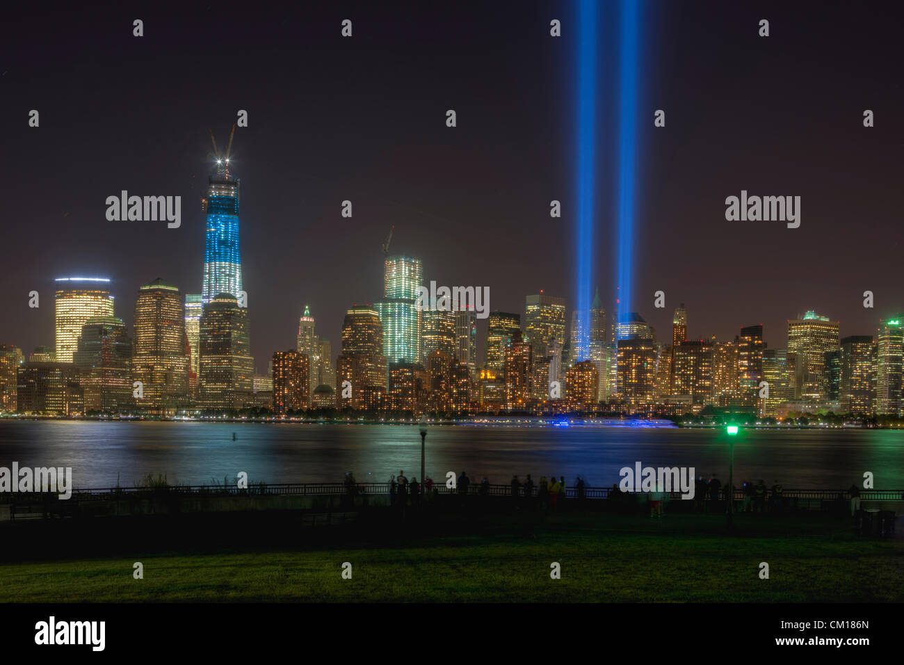 Les gens observer et photographier le double faisceau de lumière de l'hommage rendu à la lumière, un souvenir annuel des événements du 11 septembre 2001, et les toits de Manhattan du Liberty State Park, à Jersey City, New Jersey. Cette vue de la skyline comprend la Tour de la Liberté (One World Trade Center). Banque D'Images