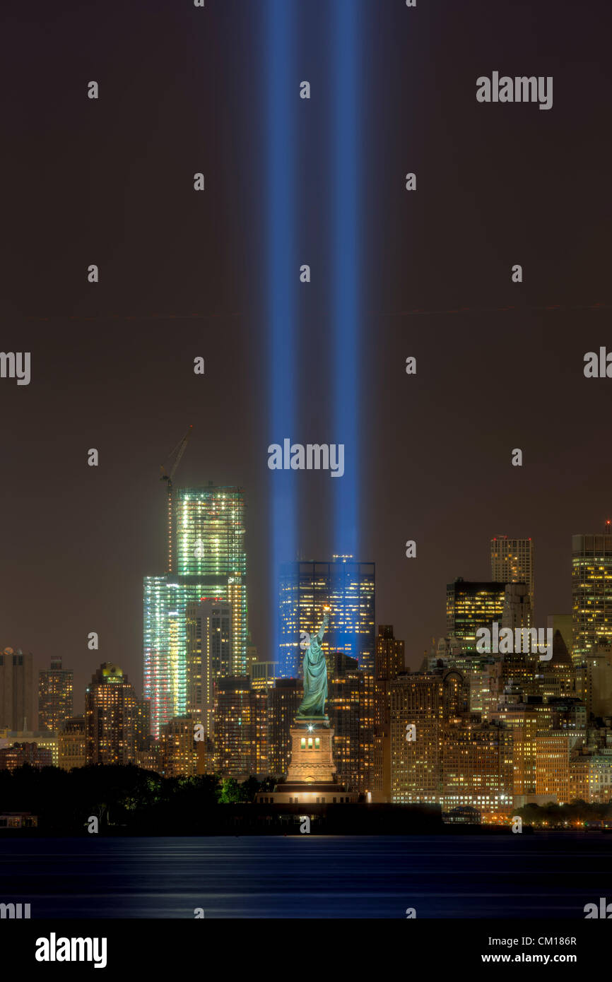 Le double faisceau de lumière de l'hommage rendu à la lumière, un souvenir annuel aux événements du 11 septembre 2001, l'éclat dans le ciel nocturne de New York City de chaque côté de la Statue de la liberté. Banque D'Images
