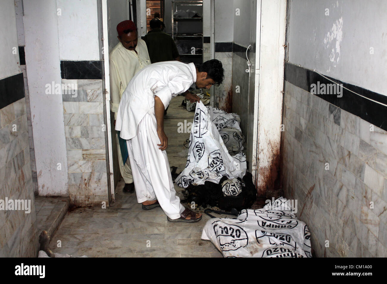 Karachi, Pakistan. 12 Septembre, 2012. Des proches de l'holocauste des ouvriers d'usine se sont réunis à une morgue de l'hôpital afin d'identifier leurs beloveds à Karachi le 12 septembre 2012. Au moins 289 travailleurs ont été brûlés lors de l'incendie a ravagé une usine de vêtements à Karachi. Banque D'Images