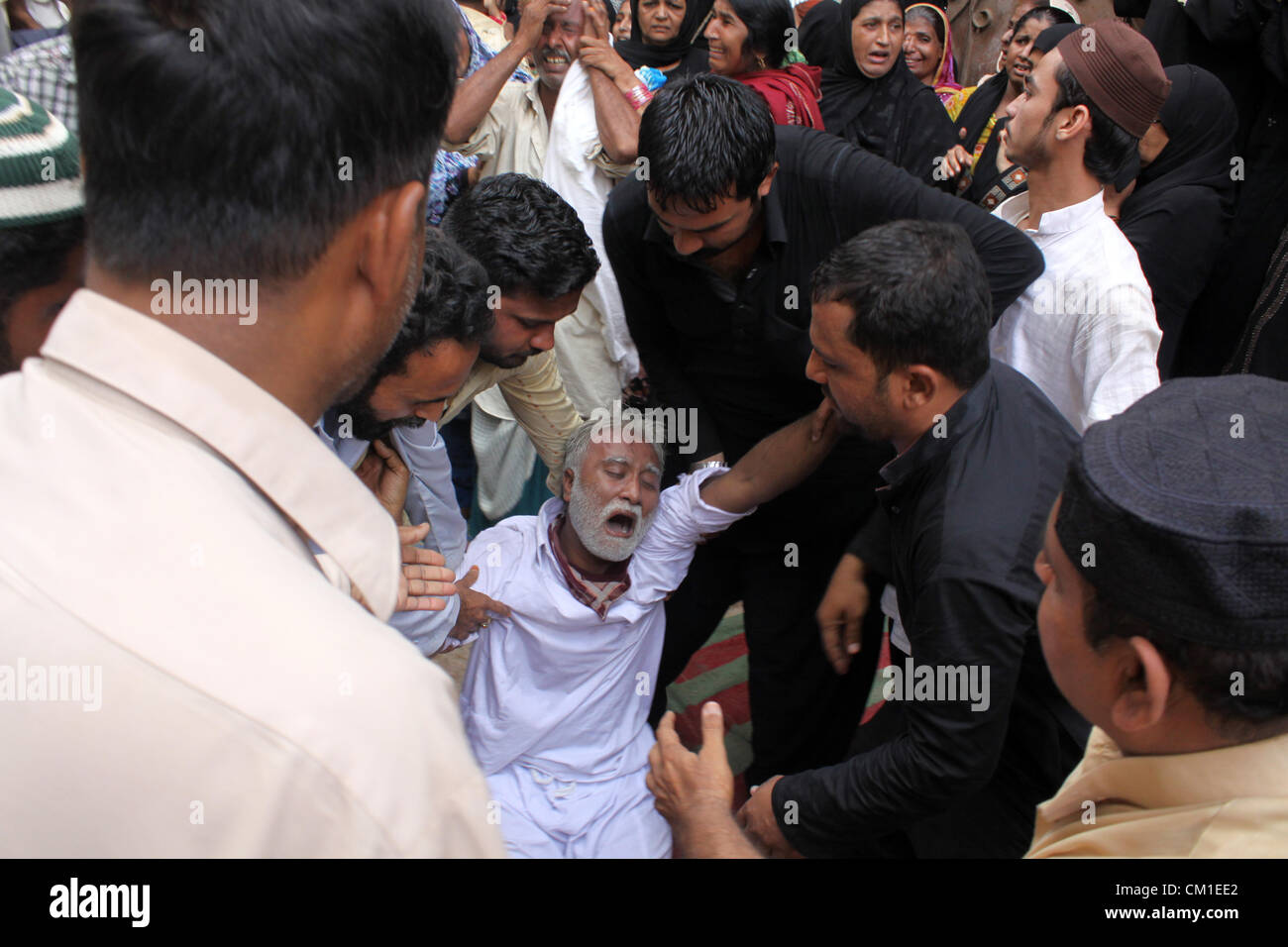 Membres de la famille de deux jeunes frères pleurent lors de funérailles à Karachi le 13 septembre 2012. Au moins 289 ouvriers étaient brûlés lorsque wild incendie a ravagé une usine de confection de mercredi. Banque D'Images