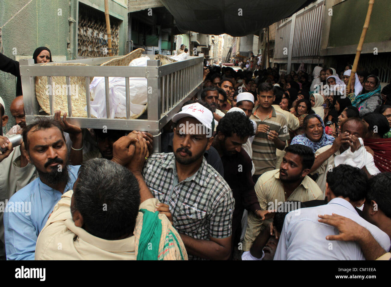 Membres de la famille de deux jeunes frères pleurent lors de funérailles à Karachi (Pakistan) le 13 septembre 2012. Au moins 289 ouvriers étaient brûlés lorsque wild incendie a ravagé une usine de confection de mercredi. Banque D'Images