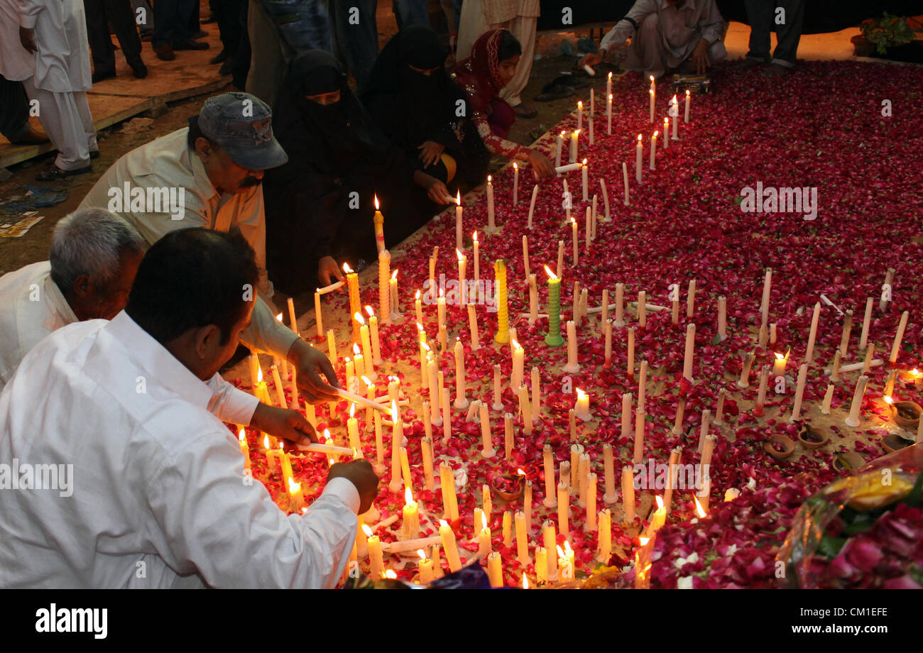 Des proches de l'holocauste des ouvriers d'usine allumer des bougies sur le site de l'incident à Karachi (Pakistan) le 13 septembre 2012. Au moins 289 travailleurs d'usine ont été brûlées lors de l'incendie a ravagé une usine de confection de mercredi. Banque D'Images