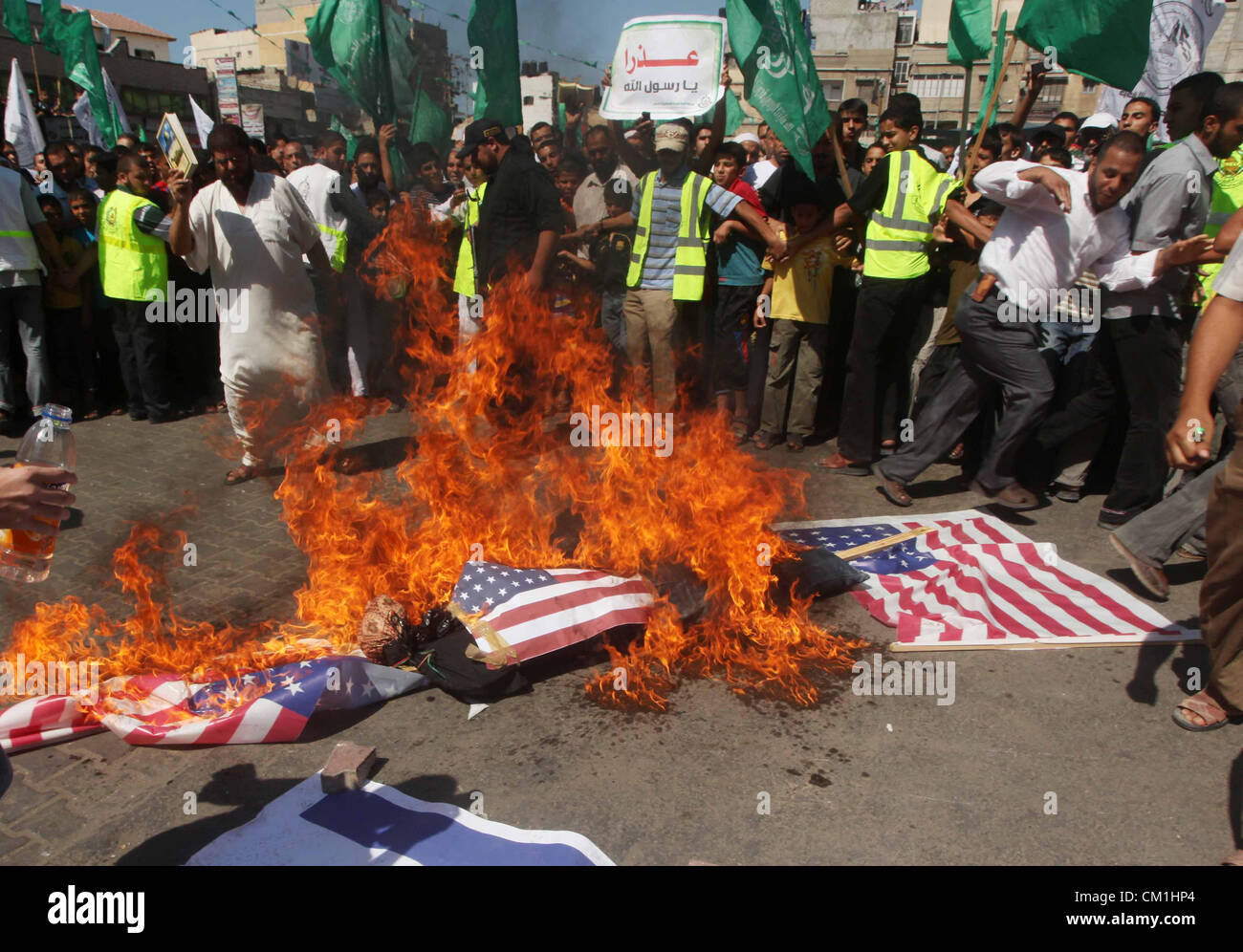 14 septembre 2012 - La ville de Gaza, bande de Gaza, territoire palestinien - Palestiniens et Israéliens brûler les drapeaux des États-Unis au cours d'une manifestation contre le film controversé "l'innocence des musulmans' à Khan Younis au sud de la bande de Gaza, le 14 septembre 2012. Le film à petit budget controversée aurait été faite par un qui dépeint les musulmans israélo-américaine comme immoral et gratuite, a suscité la fureur en Libye, où quatre américains dont l'ambassadeur ont été tués mardi quand un mob ont attaqué le consulat américain à Benghazi, et a conduit à des protestations à l'extérieur de nous les missions dans le Maroc, le Soudan, l'Egypte, la Tunisie et l'Yeme Banque D'Images