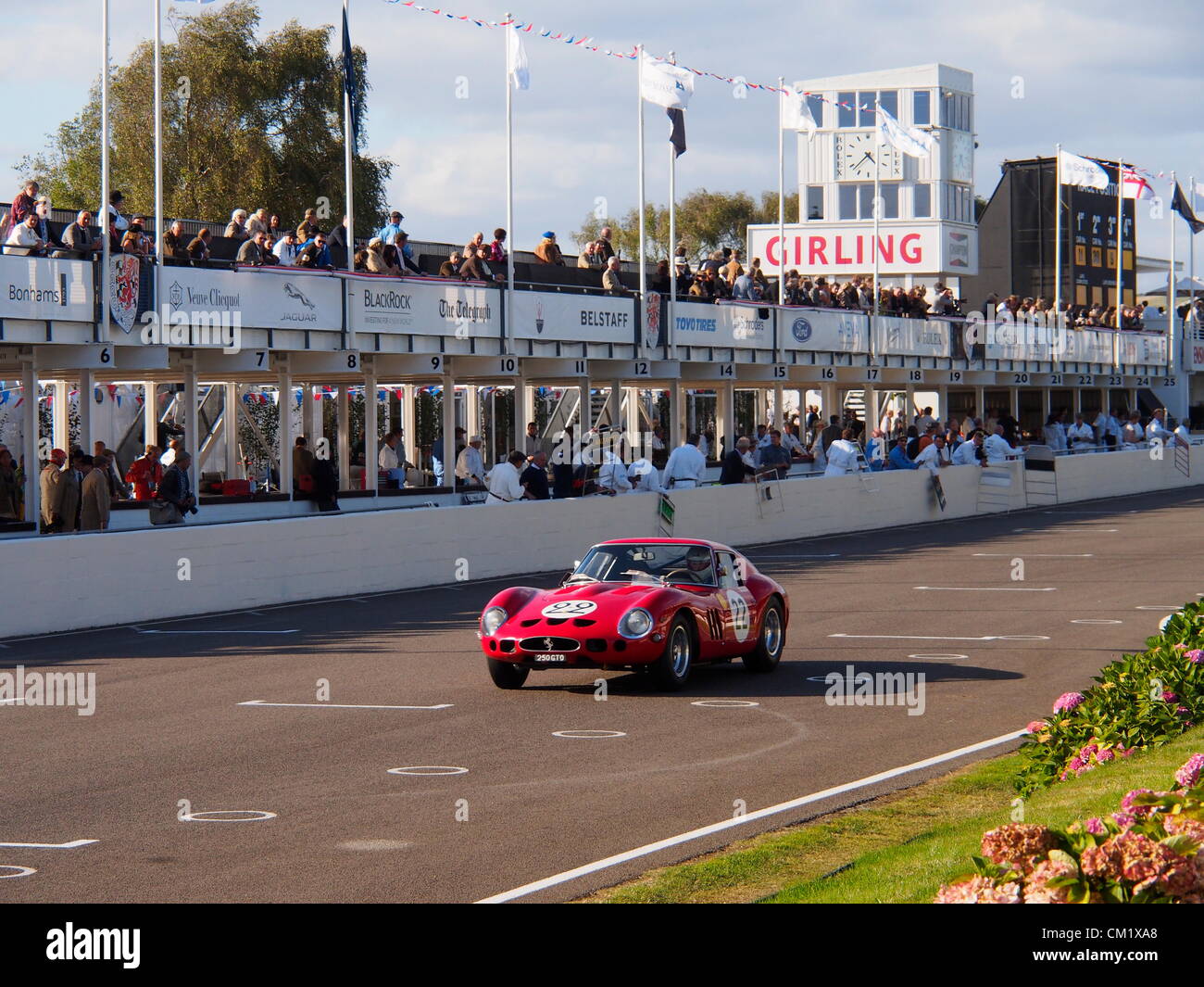 Goodwood Revival Jour de pratique vendredi 14 septembre.2012. Numéro 22 Ferrari portant une livrée rouge vif s'approche de la ligne d'arrivée en face d'ingénieurs et de spectateurs dans les fosses. Banque D'Images