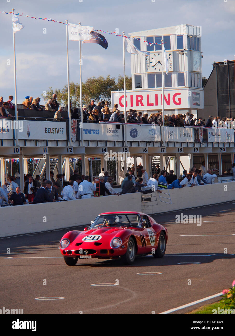 Goodwood Revival Jour de pratique vendredi 14 septembre.2012. Numéro 20 Ferrari portant une livrée rouge vif s'approche de la ligne d'arrivée en face d'ingénieurs et de spectateurs dans les fosses. Banque D'Images